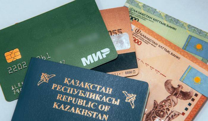 Карта Мир от банка Сбербанк, казахстанский паспорт и денежные купюры (казахстанские тенге)