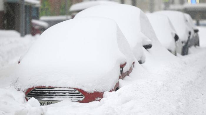 Занесенные снегом автомобили во время снегопада в Москве