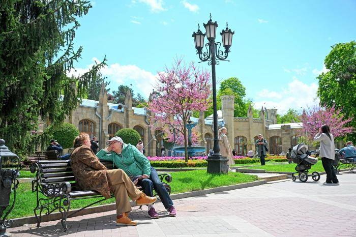 Туристы отдыхают на скамейке у Нарзанной галереи в Кисловодске