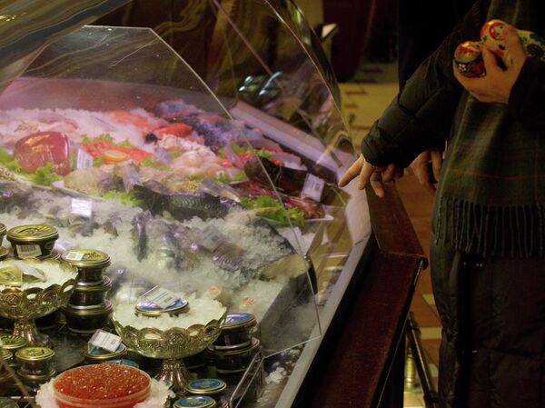 Покупатели стоят у прилавка с морепродуктами в гастрономе Елисеевский на Тверской улице