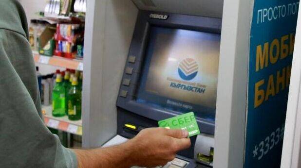 Мужчина с картой Мир от Сбербанка у банкомата в Бишкеке