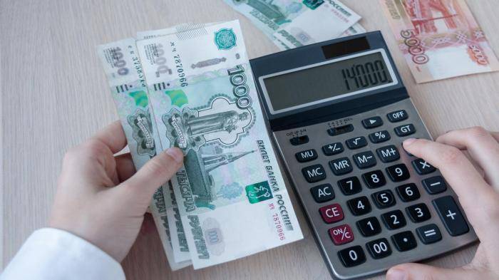 Девушка считает прибыль на калькуляторе