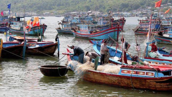 Рыбаки перебирают сеть после ловли рыбы в заливе Нячанг