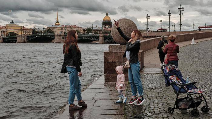 Прохожие на набережной Невы в Санкт-Петербурге