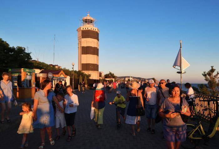 Люди гуляют возле Анапского маяка на берегу Черного моря