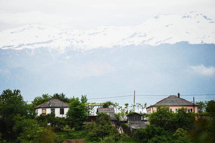 Дома местных жителей на фоне заснеженных гор