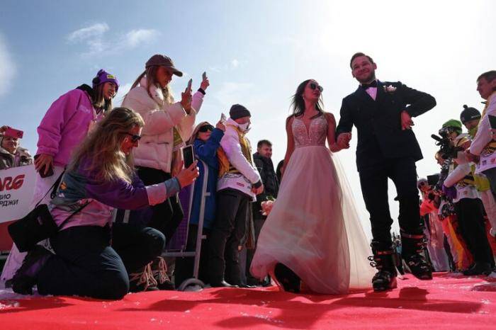 Участники Свадебного горнолыжного спуска на торжественной регистрации брака у подножия горы Зеленая в Шерегеше во время фестиваля GrelkaFest