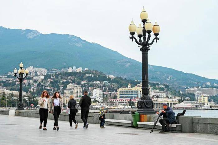 Отдыхающие гуляют по набережной Ялты