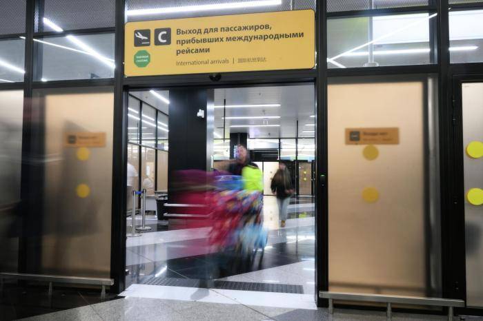 Пассажиры на выходе из зоны прилета международных рейсов в аэропорту Шереметьево в Подмосковье