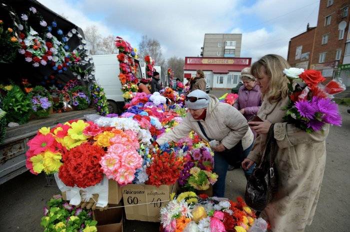 Женщины покупают искусственные цветы в День поминовения (Радоница)