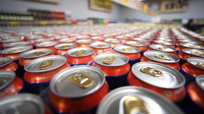 Банки с газированным напитком на прилавке магазина