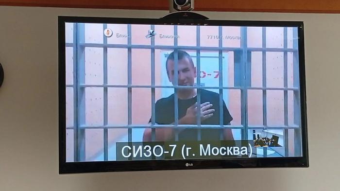 Илья Ремесло на экране монитора во время судебного заседания
